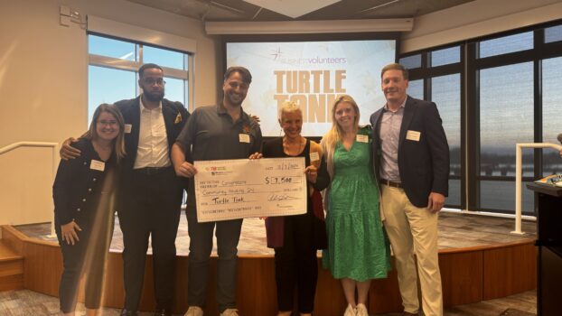 GIVE Fellows pose with the executive director of Cornerstone Community Housing. Turtle Tank Judge Tony Scotto of THB holds their check for winning 1st place.